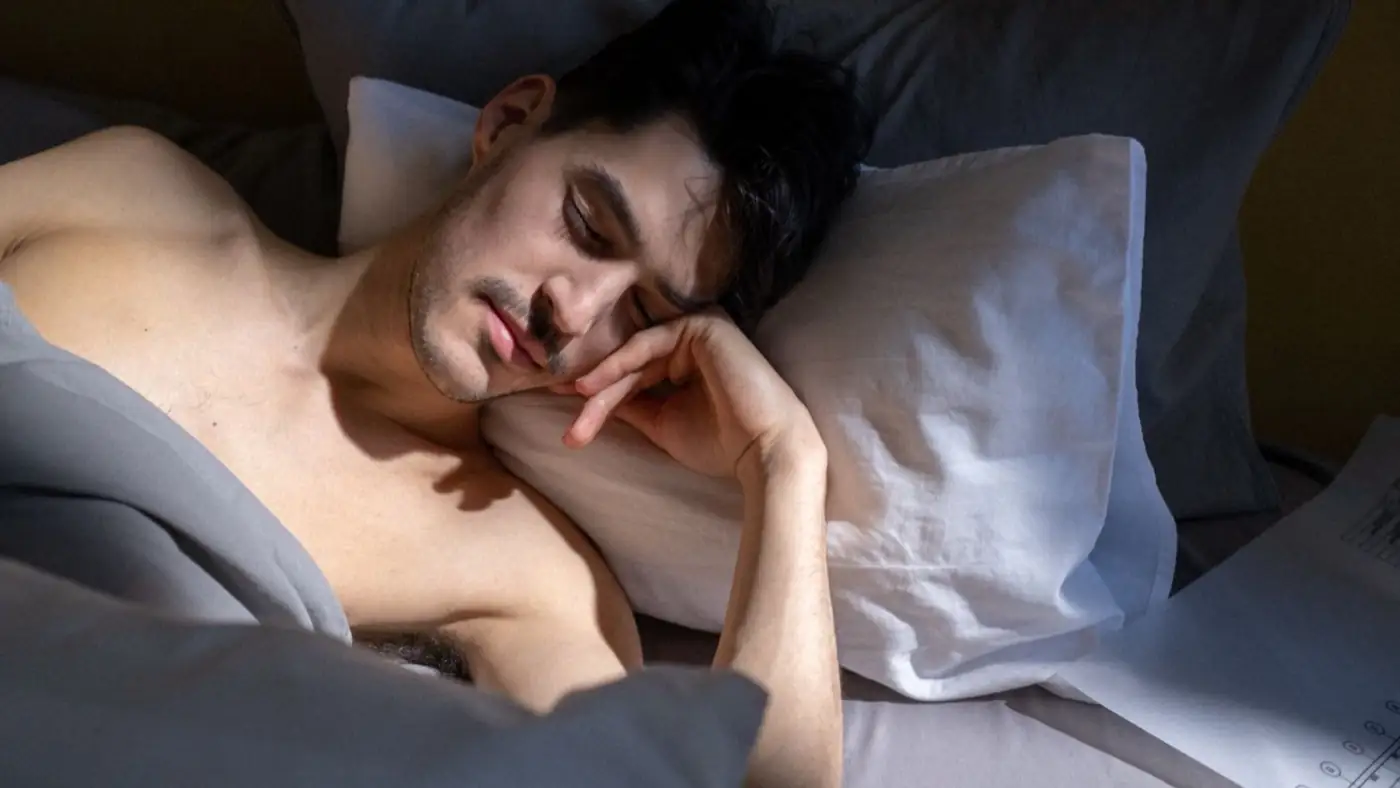 Mujer adulta duerme de lado en la cama